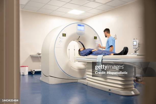 un médecin prépare un patient pour un examen médical à l’hôpital - tomographie par émission de positrons photos et images de collection