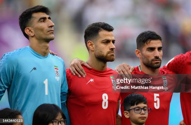 Alireza Beiranvand, Morteza Pouraliganji and Morteza Pouraliganji of IR Iran line up for the national anthem prior to the FIFA World Cup Qatar 2022...