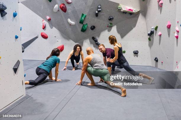 alpinistas interiores se alongando e se preparando para escalar uma parede - bouldering - fotografias e filmes do acervo