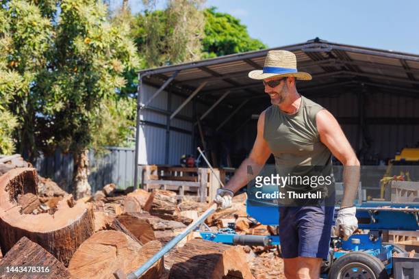 australian man chopping firewood - stronk stockfoto's en -beelden