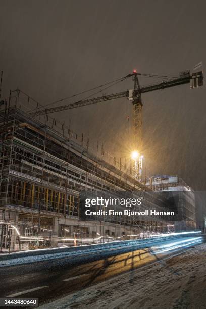 construction site with large crane in the evening in snowy weather - finn bjurvoll stock pictures, royalty-free photos & images