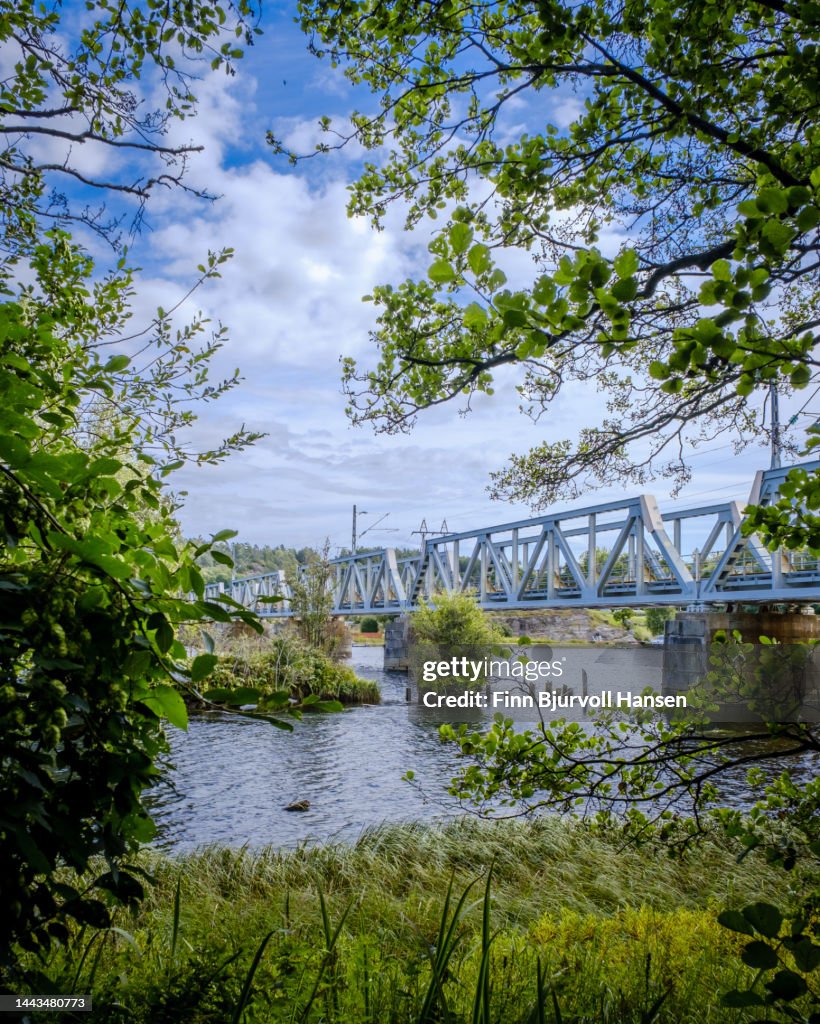 Railway bridge over the river Lagen in Larvik Norway. The picture was taken through an opening in the bushes