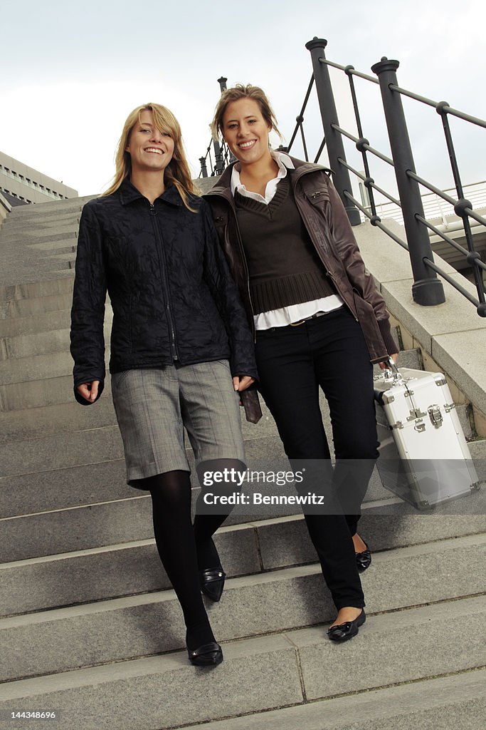 Two woman walking down a staircase