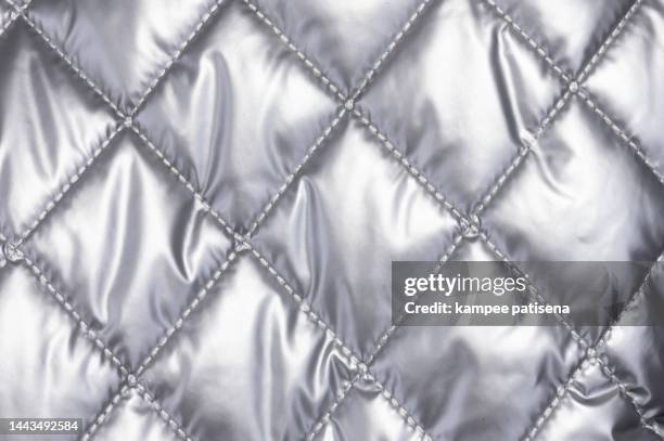 quilted cloth, full frame shot of sivler fabric. - ダウンジャケット ストックフォトと画像