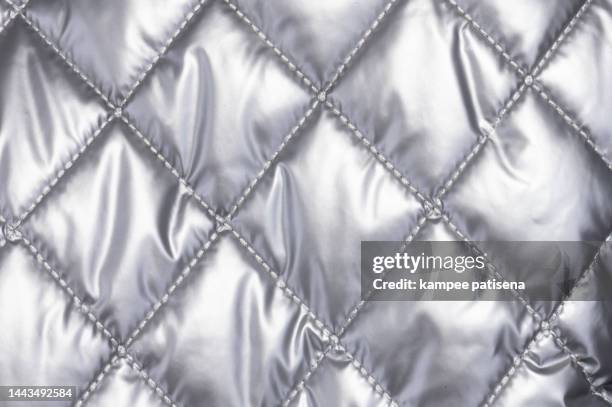 quilted cloth, full frame shot of sivler fabric. - gray jacket stockfoto's en -beelden