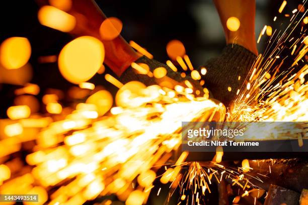structural and building engineering. close-up shot of a metal worker cutting or grinding for a finish metal element construction frame with a grinder saw in a metal workshop. - electric arc furnace - fotografias e filmes do acervo