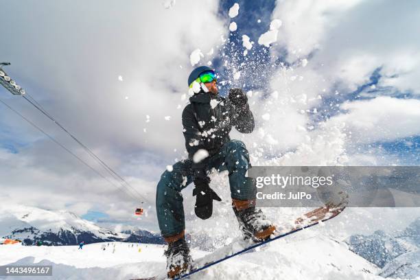young adult man jumping on snowboard in mountains - snowboard jump close up stock pictures, royalty-free photos & images