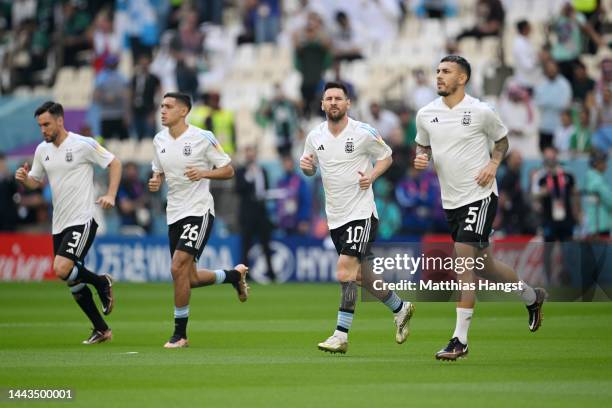 Nicolas Tagliafico, Nahuel Molina, Lionel Messi and Leandro Paredes of Argentina warm up prior to the FIFA World Cup Qatar 2022 Group C match between...