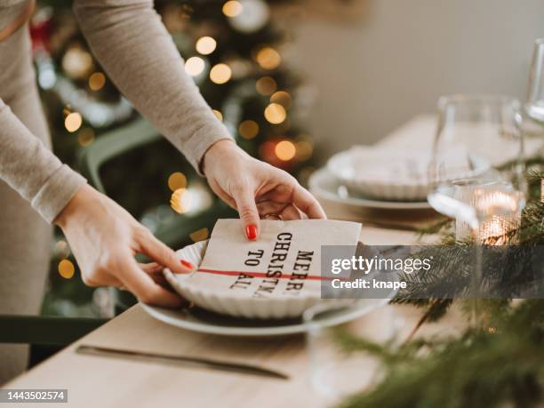 woman setting the christmas table preparing for dinner party - table setting stock pictures, royalty-free photos & images