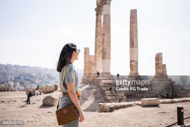 mid adult woman tourist admiring antique columns in amman city, jordan - jordan amman stock pictures, royalty-free photos & images