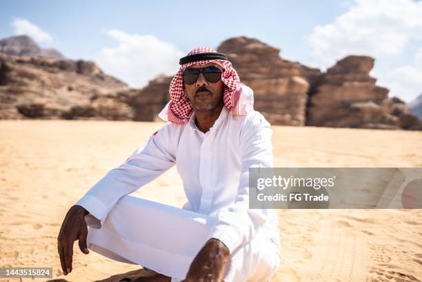 portrait of a mature middle eastern man at desert - kaffiyeh stock pictures, royalty-free photos & images