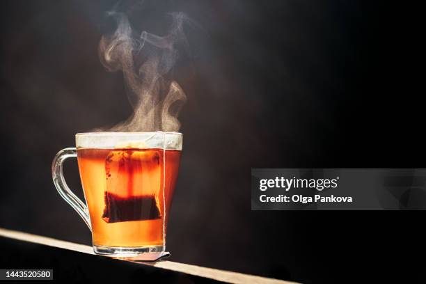 glass cup with tea and tea bag - black tea stock pictures, royalty-free photos & images