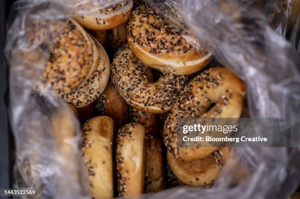 a bag of  bagels - poppy seed stock-fotos und bilder