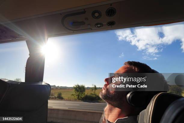 man sitting on coach - car journey photos et images de collection