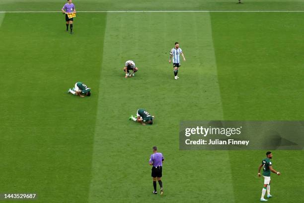 Lionel Messi of Argentina shows their dejection as Saudi Arabia players celebrate the 2-1 win during the FIFA World Cup Qatar 2022 Group C match...