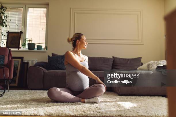 young pregnant woman doing prenatal yoga at home - prenatal yoga stock pictures, royalty-free photos & images