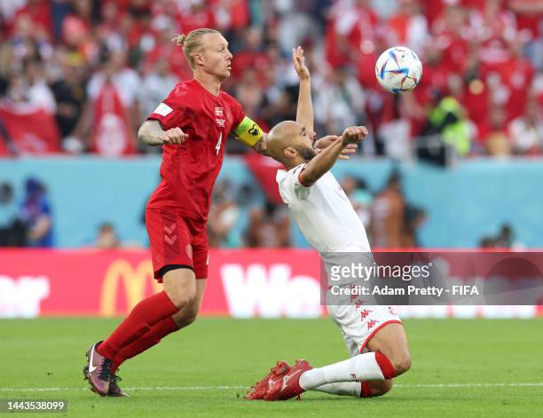 Issam Jebali of Tunisia is challenged by Simon Kjaer of Denmark during the FIFA World Cup Qatar 2022 Group D match between Denmark and Tunisia at...