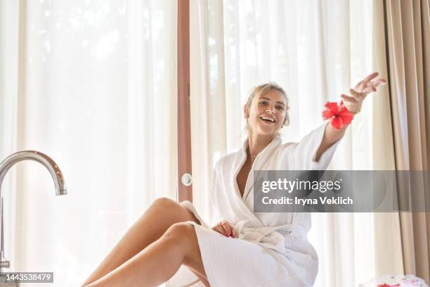 attractive young woman feels happy and enjoys a bath with foam and  rose flower petals. - robe tube stock pictures, royalty-free photos & images