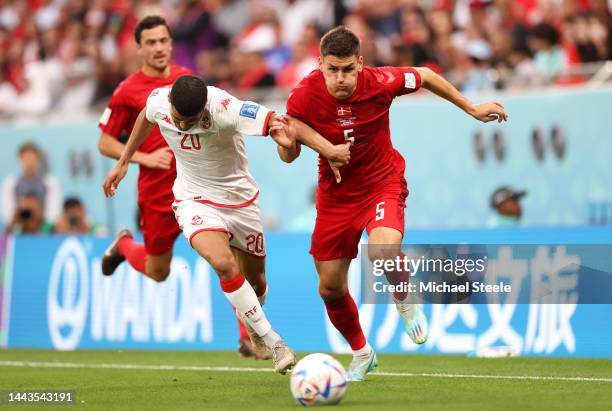 Joakim Maehle of Denmark and Mohamed Drager of Tunisia battle for the ball during the FIFA World Cup Qatar 2022 Group D match between Denmark and...