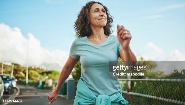 donna matura sorridente fuori per una passeggiata di potere in estate - camminare foto e immagini stock