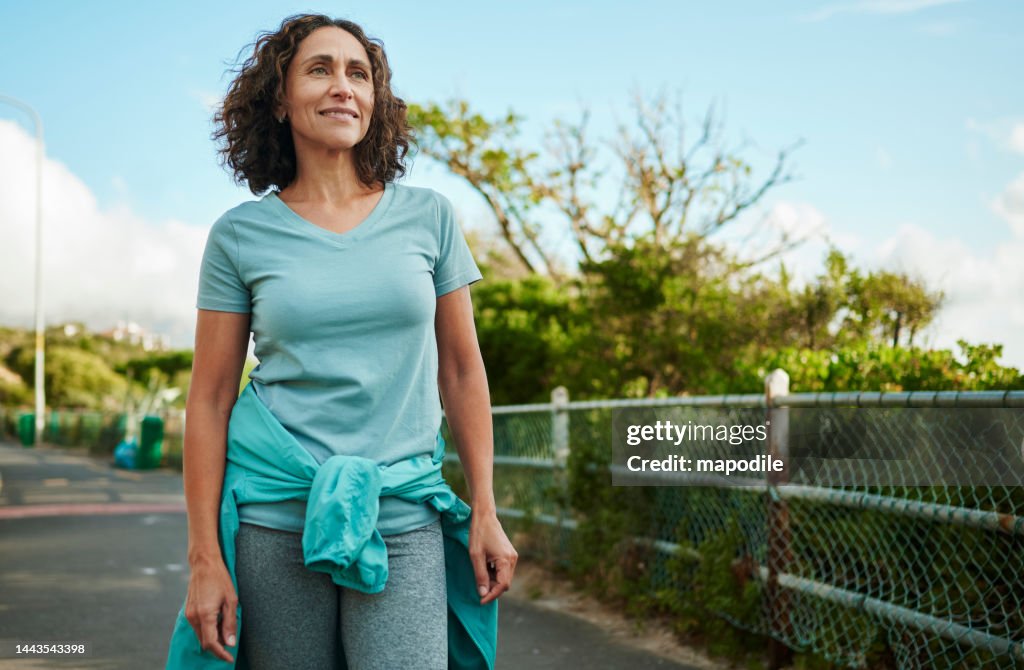 Smiling mature woman in sportswear out for a walking in summer