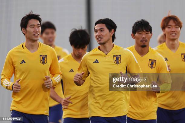 Takumi Minamino of Japan warms up with teammates during the Japan Training Session at Al Sadd New Training Facilities on November 22, 2022 in Doha,...