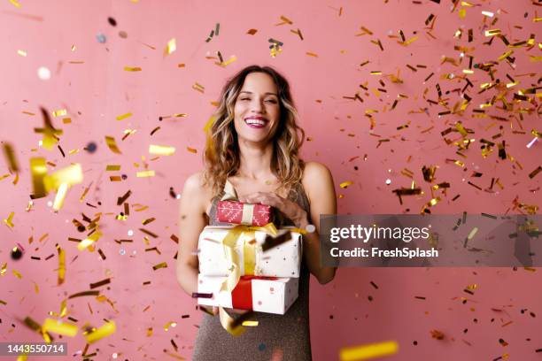 a happy woman standing in confetti rain and holding beautifully - woman ribbon happy stockfoto's en -beelden