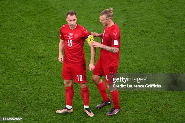 Simon Kjaer of Denmark passes the No Discrimination captain's armband to Christian Eriksen during the FIFA World Cup Qatar 2022 Group D match between...
