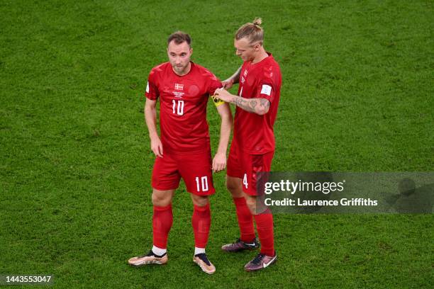 Simon Kjaer of Denmark passes the No Discrimination captain's armband to Christian Eriksen during the FIFA World Cup Qatar 2022 Group D match between...