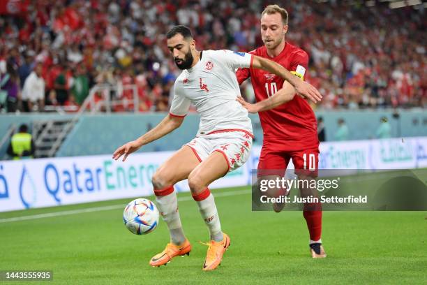 Christian Eriksen of Denmark battles for possession with Yassine Meriah of Tunisia during the FIFA World Cup Qatar 2022 Group D match between Denmark...