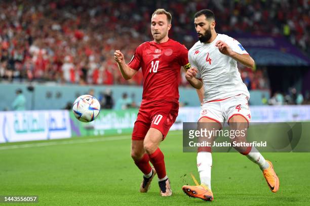 Christian Eriksen of Denmark battles for possession with Yassine Meriah of Tunisia during the FIFA World Cup Qatar 2022 Group D match between Denmark...
