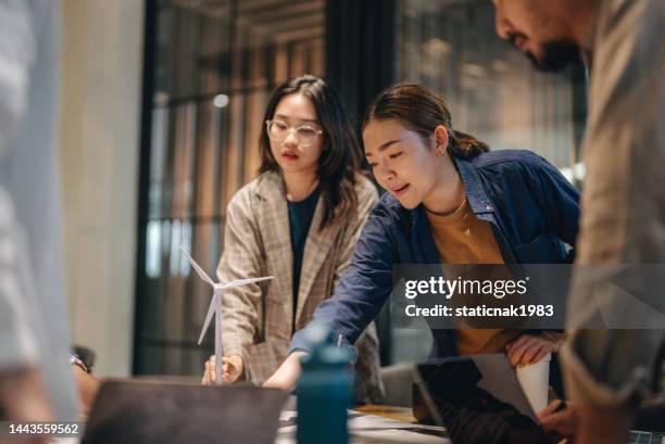il team di architetti asiatici parla di un nuovo progetto in ufficio. - business sostenibile foto e immagini stock