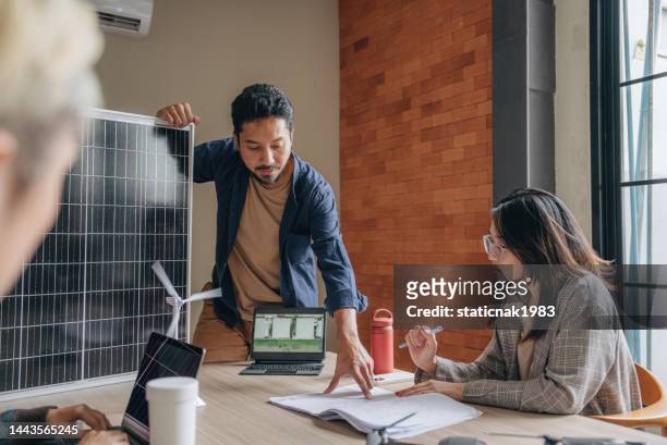asiatischer geschäftsmann im gespräch mit seinen kollegen bei der präsentation im büro. - sustainability business stock-fotos und bilder
