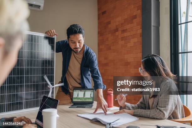 homme d’affaires asiatique parlant à ses collègues lors d’une présentation au bureau. - technologie verte photos et images de collection