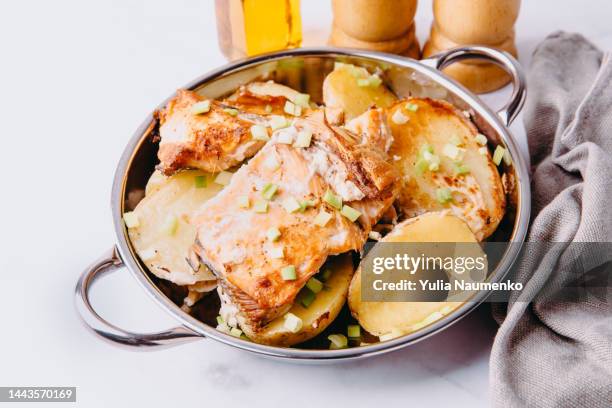 oven-baked fish pieces with potatoes and herbs. - gebackener lachs stock-fotos und bilder