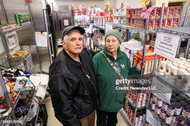 Huntington Station, N.Y.: Anthony and Teresa Caruso, of Huntington Station, stand next to shelves of canned goods inside the Island Cares food bank...