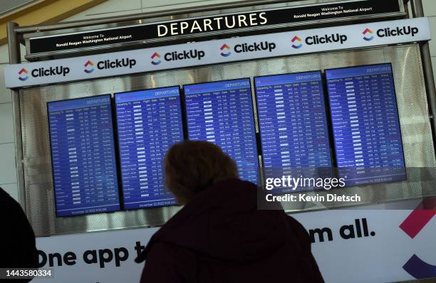 Passengers looks at a departure schedule at Ronald Reagan Washington National Airport on November 22, 2022 in Arlington, Virginia. Airlines are...