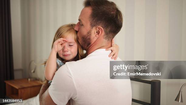 father comforting his upset and sad daughter indoors - daddy and baby girl stock pictures, royalty-free photos & images