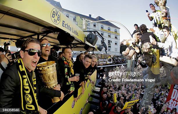 Roman Weidenfeller, head coach Juergen Klopp and Kevin Grosskreutz celebrate during a victory parade on an open top bus after winning the DFB Cup and...