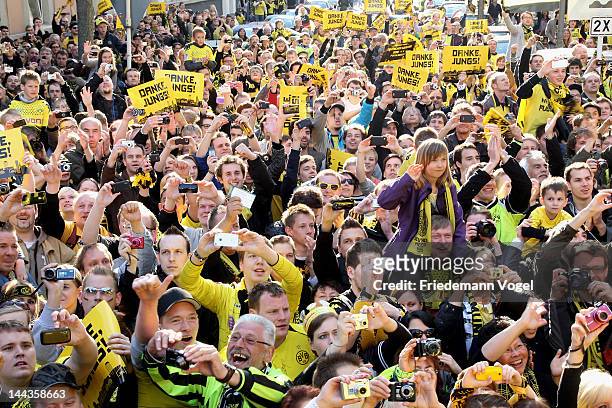Fans of Dortmund celebrates during a victory parade after winning the DFB Cup and Bundesliga Trophy, on May 13, 2012 in Dortmund, Germany.