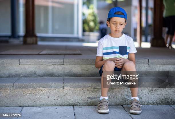 kid sitting on stairs and feeling sad - alleen jongens stockfoto's en -beelden