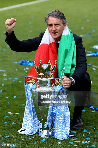 Roberto Mancini the manager of Manchester City celebrates with the trophy following the Barclays Premier League match between Manchester City and...