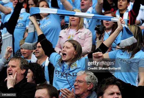 Manchester City fans celebrate following the Barclays Premier League match between Manchester City and Queens Park Rangers at the Etihad Stadium on...