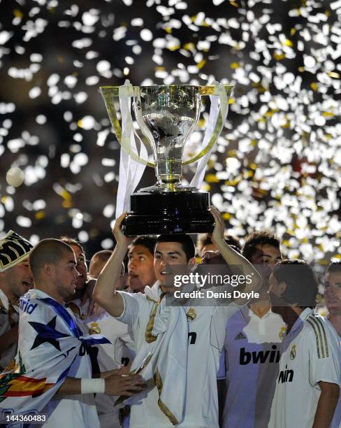 Cristiano Ronaldo of Real Madrid CF holds up the La Liga trophy as he celebrates with team-mates after the La Liga match between Real Madrid CF and...