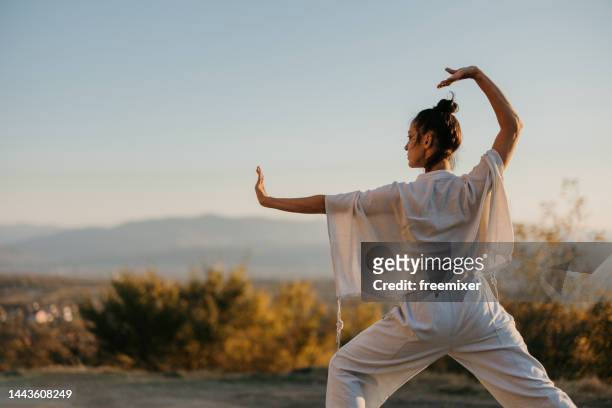 woman doing tai chi - practising tai-chi stock pictures, royalty-free photos & images