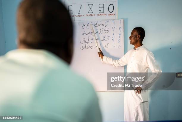 teacher teaching student in the classroom - arabic script stock pictures, royalty-free photos & images
