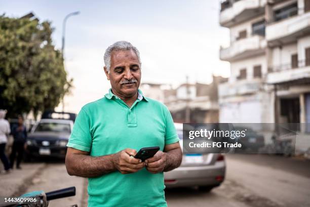 mature man using smartphone outdoors - egyptian culture stock pictures, royalty-free photos & images