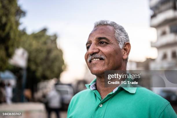 mature man looking away contemplating outdoors - arab man stock pictures, royalty-free photos & images