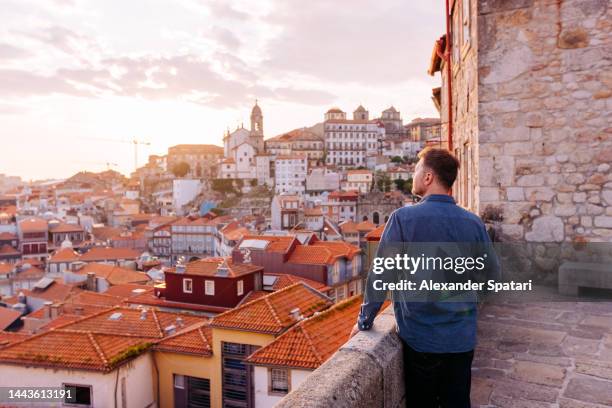 man looking at porto old town skyline at sunset, portugal - porto portugal stock-fotos und bilder