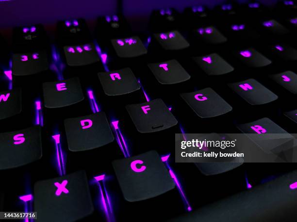 gaming computer keyboard keys with purple pink lights - illuminated alphabet stock pictures, royalty-free photos & images